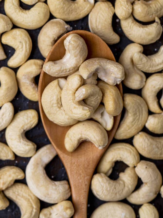 top-view-wooden-spoon-with-cashew-black-background